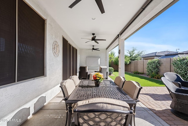 view of patio featuring ceiling fan, fence, and outdoor dining space