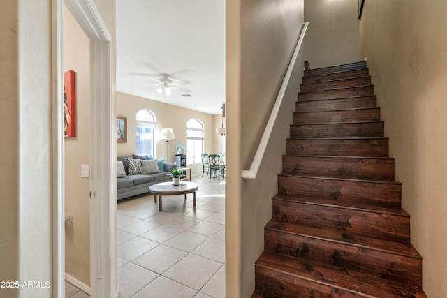 stairway featuring tile patterned floors and ceiling fan