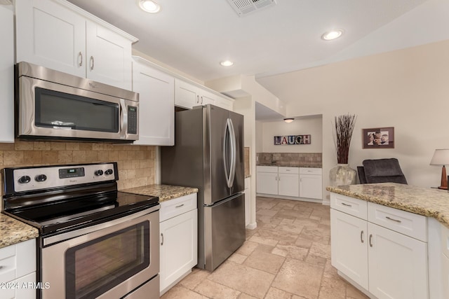 kitchen featuring appliances with stainless steel finishes, backsplash, white cabinetry, and light stone counters