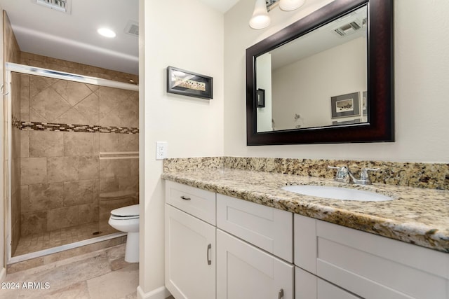 bathroom with vanity, toilet, and a shower with door