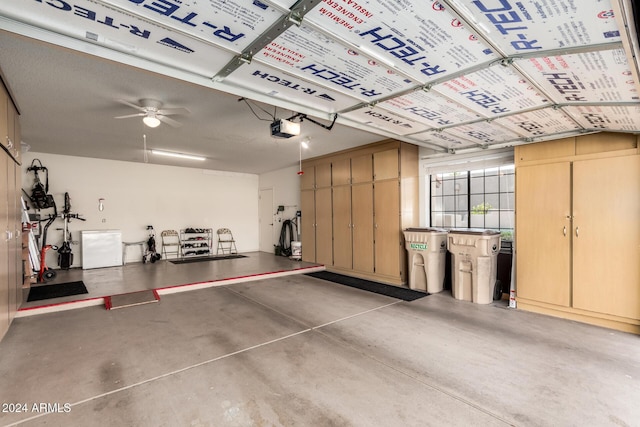 garage with ceiling fan, white refrigerator, and a garage door opener