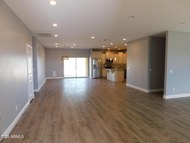 unfurnished living room featuring sink and dark wood-type flooring