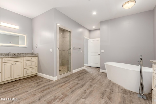 bathroom with hardwood / wood-style flooring, vanity, and independent shower and bath