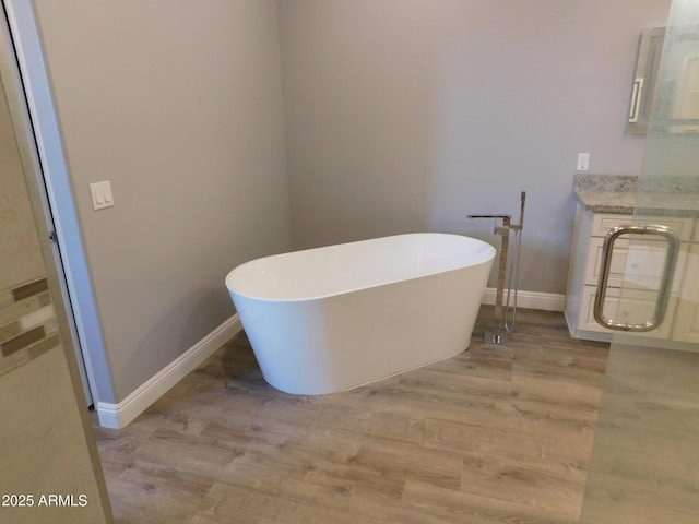 bathroom with a washtub and hardwood / wood-style flooring