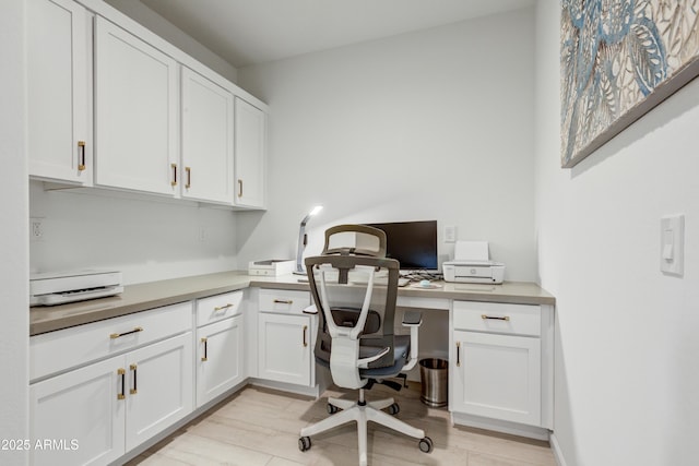 office area with built in desk and light wood-type flooring