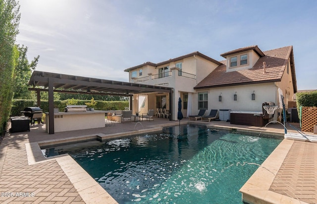 outdoor pool featuring exterior kitchen, a jacuzzi, area for grilling, and a patio