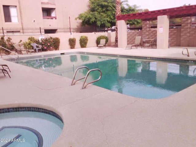 view of pool featuring a patio and a hot tub