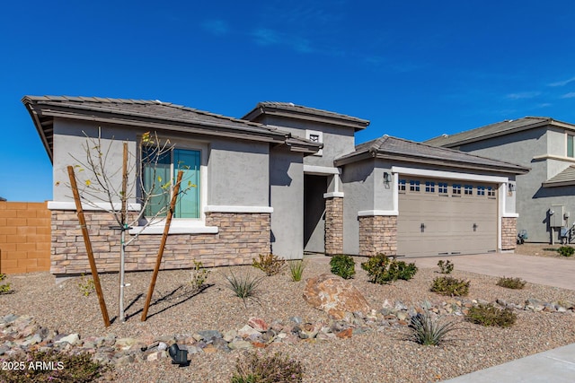 prairie-style house featuring a garage, stone siding, concrete driveway, and stucco siding