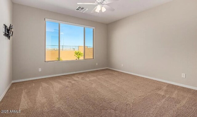 spare room with a ceiling fan, carpet, visible vents, and baseboards