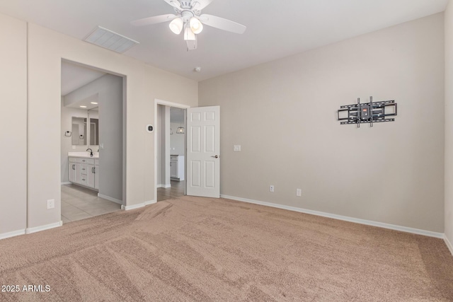 unfurnished bedroom with light carpet, baseboards, visible vents, and a sink