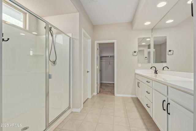 bathroom with tile patterned floors, a walk in closet, vanity, a shower stall, and recessed lighting