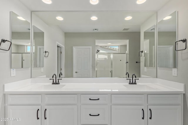 bathroom with double vanity, a stall shower, a sink, and recessed lighting