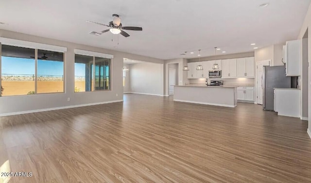 unfurnished living room with ceiling fan, baseboards, dark wood-style flooring, and recessed lighting