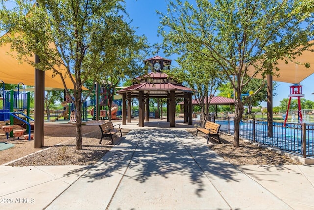 view of community with fence, playground community, and a gazebo