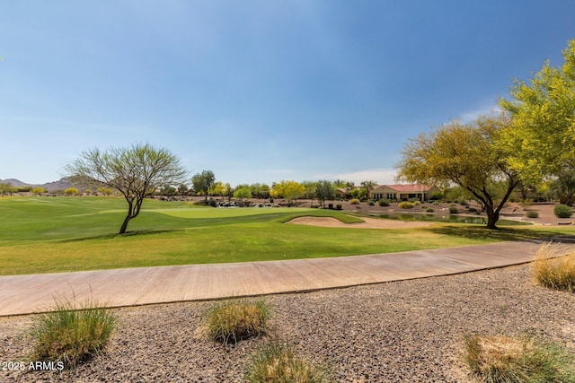 view of community with golf course view and a yard