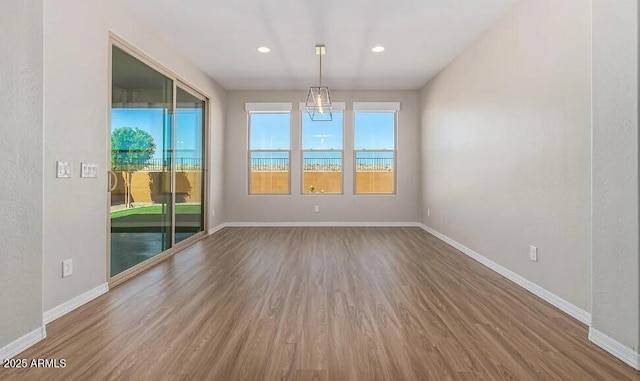 spare room featuring baseboards, wood finished floors, and recessed lighting