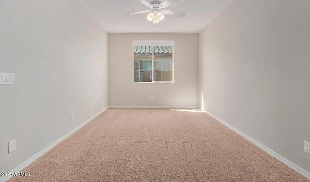 carpeted empty room featuring a ceiling fan and baseboards