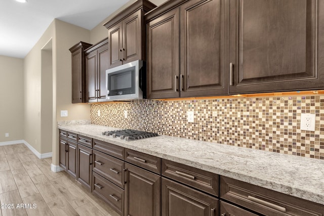 10350 E Texas Ave, Mesa, AZ 85212 - kitchen with stainless steel appliances, baseboards, dark brown cabinets, backsplash, and light wood-style floors