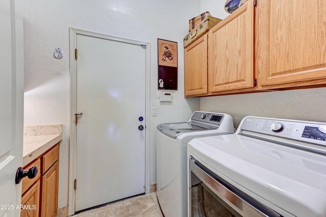 laundry room featuring independent washer and dryer and cabinet space