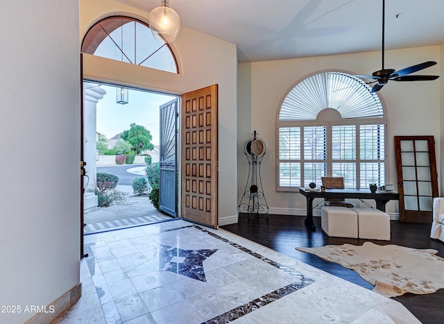 entryway with baseboards, a ceiling fan, and wood finished floors