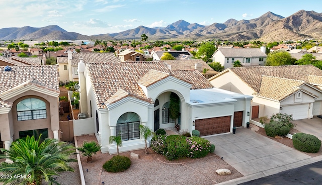 mediterranean / spanish house featuring a tile roof, an attached garage, stucco siding, a residential view, and driveway