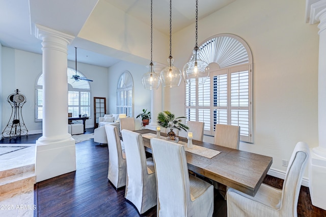 dining room with decorative columns, dark wood-style flooring, baseboards, and vaulted ceiling
