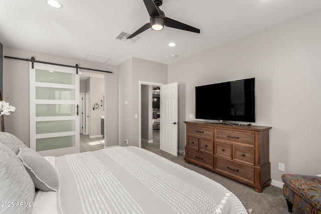 bedroom featuring ceiling fan, a barn door, and light carpet