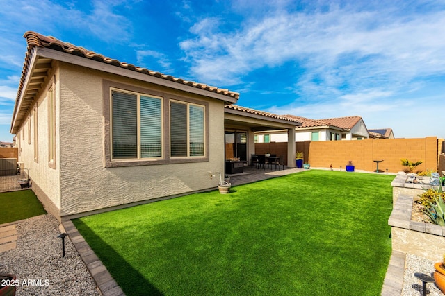 back of house with a yard and a patio area