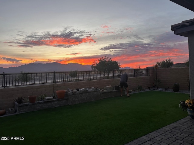 yard at dusk featuring a mountain view