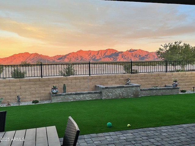 yard at dusk featuring a mountain view