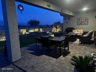 patio at night featuring outdoor lounge area