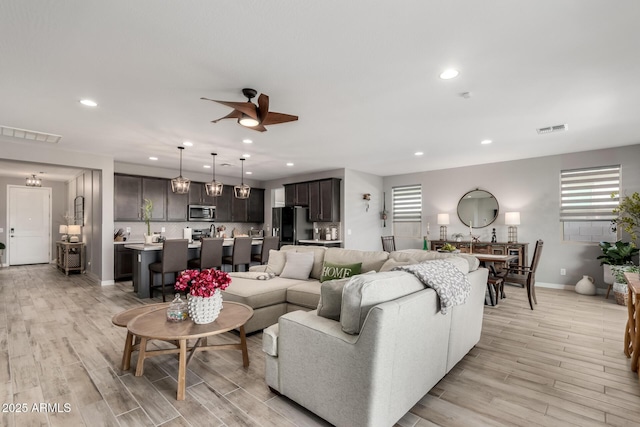 living room featuring ceiling fan and light wood-type flooring