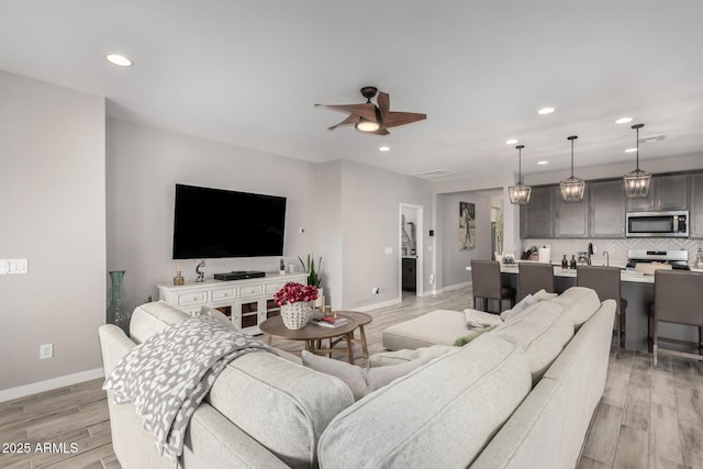 living room featuring light hardwood / wood-style flooring and ceiling fan