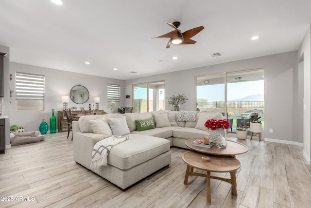 living room featuring light hardwood / wood-style floors and ceiling fan