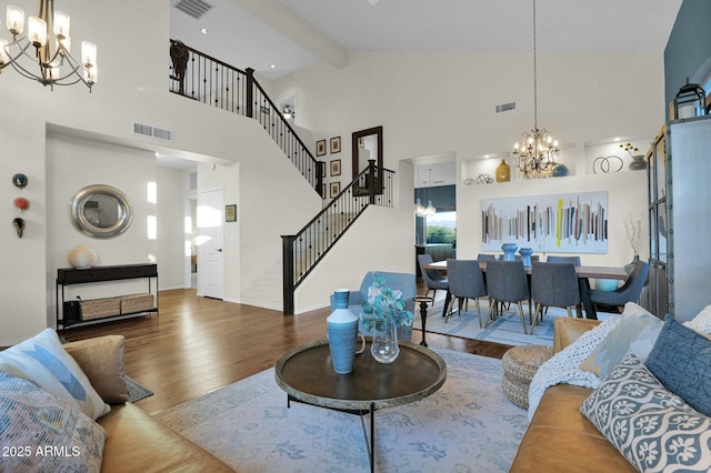 living room with beam ceiling, hardwood / wood-style floors, a chandelier, and high vaulted ceiling