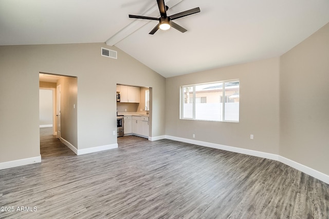 unfurnished living room featuring ceiling fan, wood finished floors, beam ceiling, a sink, and baseboards