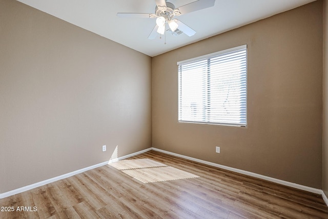 unfurnished room with wood finished floors, baseboards, and a ceiling fan