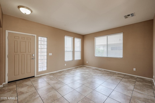 foyer entrance with light tile patterned floors, baseboards, and visible vents