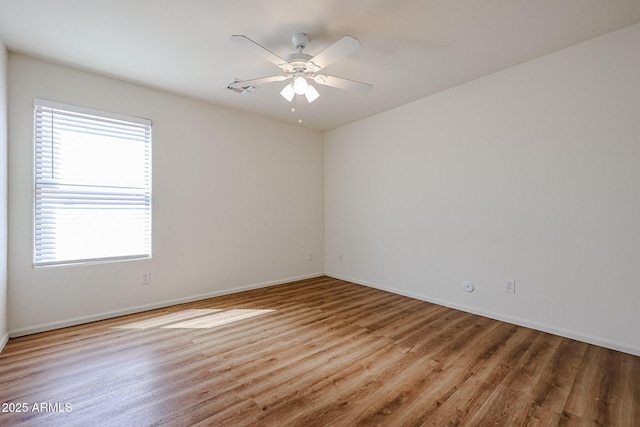 unfurnished room with visible vents, baseboards, a ceiling fan, and wood finished floors