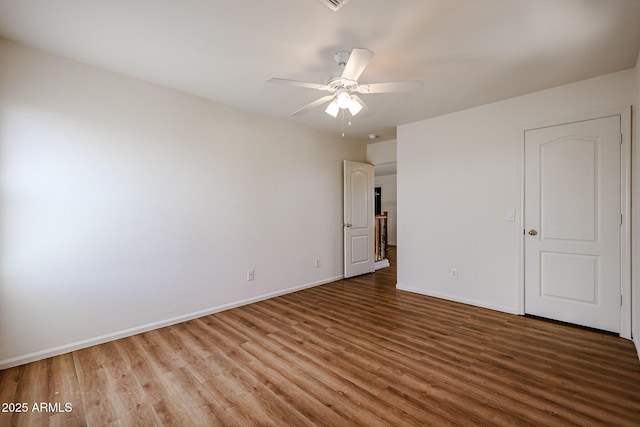 unfurnished bedroom with wood finished floors, baseboards, and a ceiling fan