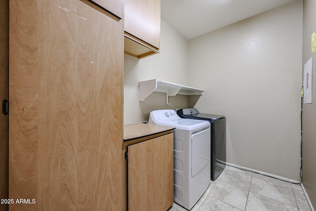 laundry room featuring light tile patterned floors, washing machine and dryer, and cabinet space