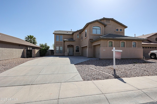 view of front of home with fence, a garage, driveway, and stucco siding