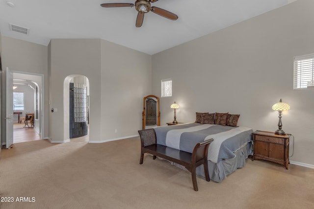 bedroom featuring ceiling fan, a towering ceiling, and light colored carpet