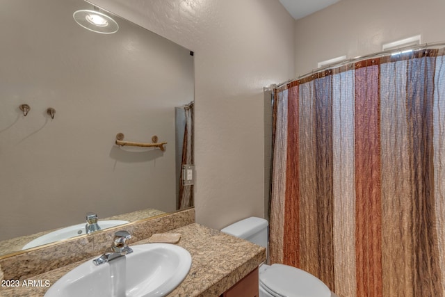 bathroom with vanity, toilet, and walk in shower