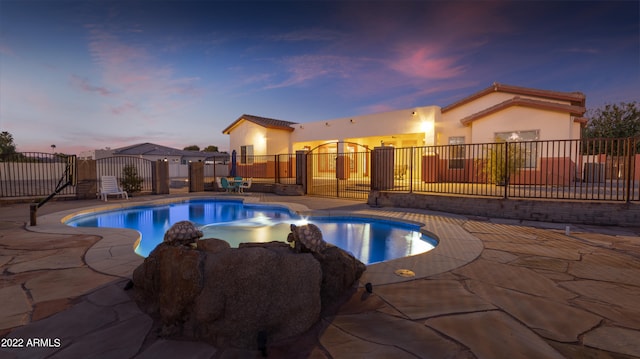 pool at dusk featuring a patio area