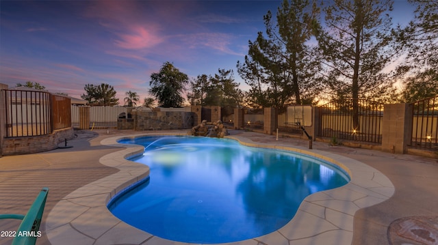 pool at dusk featuring a patio area