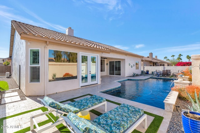 view of pool featuring french doors, pool water feature, and a patio