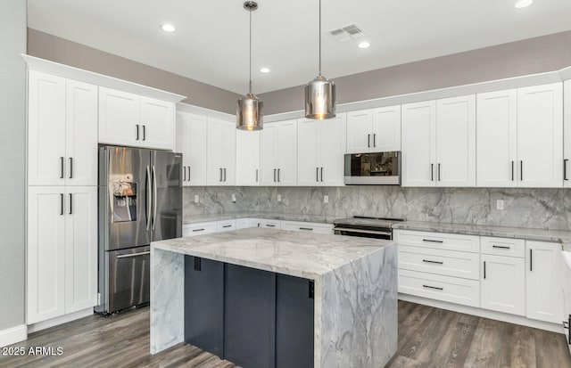 kitchen with stainless steel appliances, decorative light fixtures, white cabinetry, a center island, and light stone counters