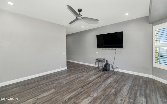 unfurnished living room with ceiling fan and dark wood-type flooring