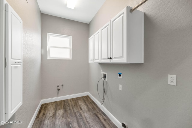 washroom featuring dark wood-type flooring, cabinets, hookup for a gas dryer, and washer hookup